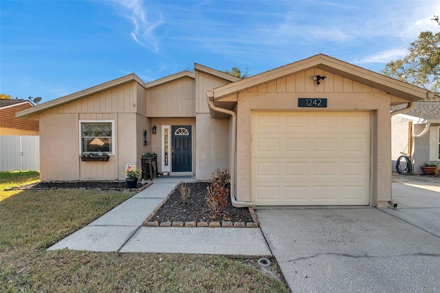 ranch-style home with a garage and a front lawn