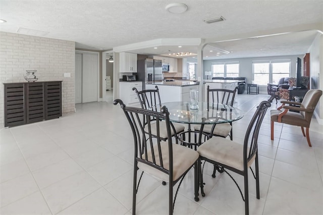 dining room with light tile patterned floors and a textured ceiling