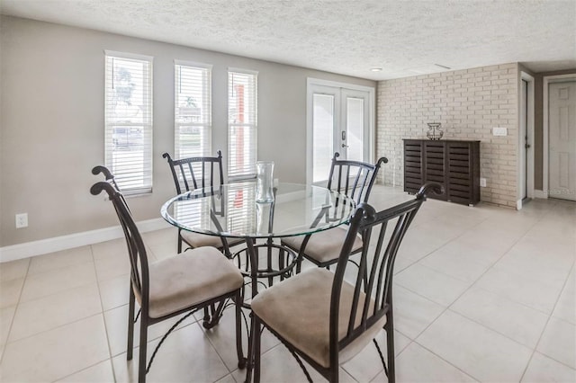 tiled dining space featuring a fireplace, french doors, and a textured ceiling