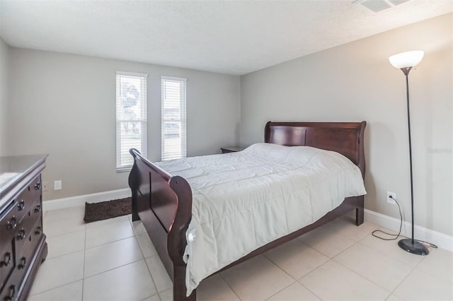 bedroom with light tile patterned flooring and a textured ceiling