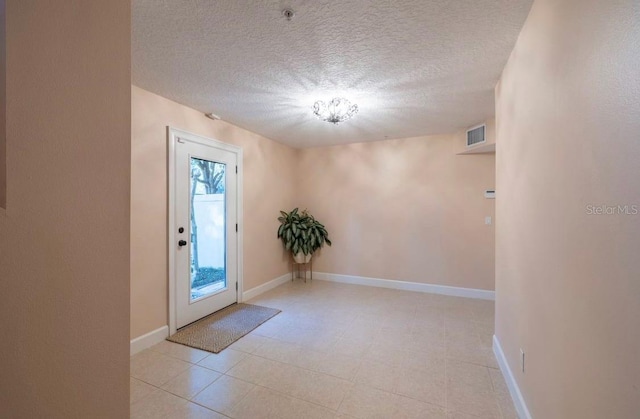 doorway to outside featuring a textured ceiling