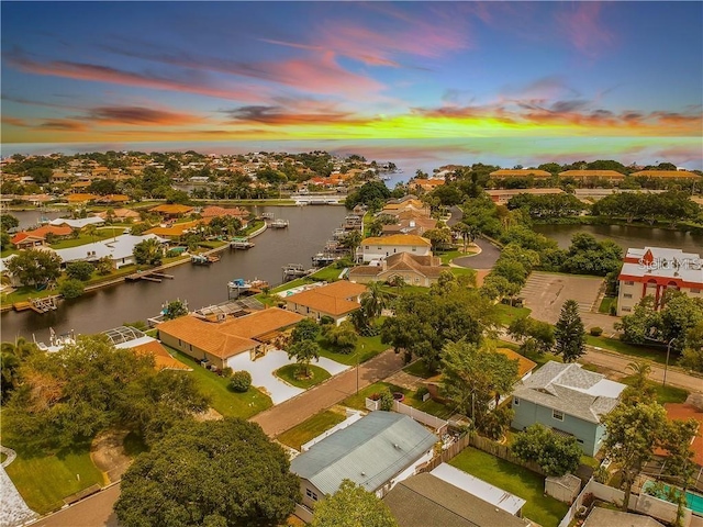 aerial view at dusk featuring a water view