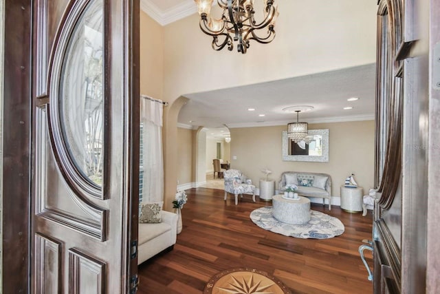 foyer entrance with a notable chandelier, crown molding, and dark wood-type flooring