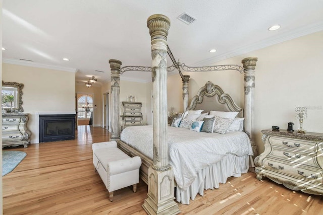 bedroom with ornamental molding and light hardwood / wood-style flooring