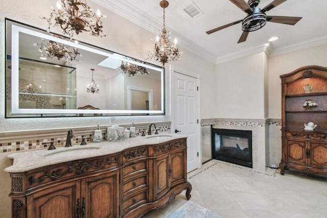 bathroom with crown molding, tile patterned floors, vanity, and a tile fireplace