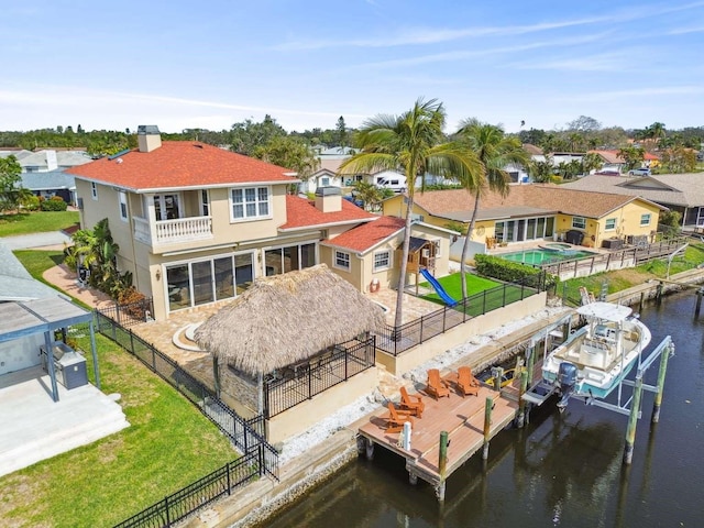 back of house featuring a water view and a yard