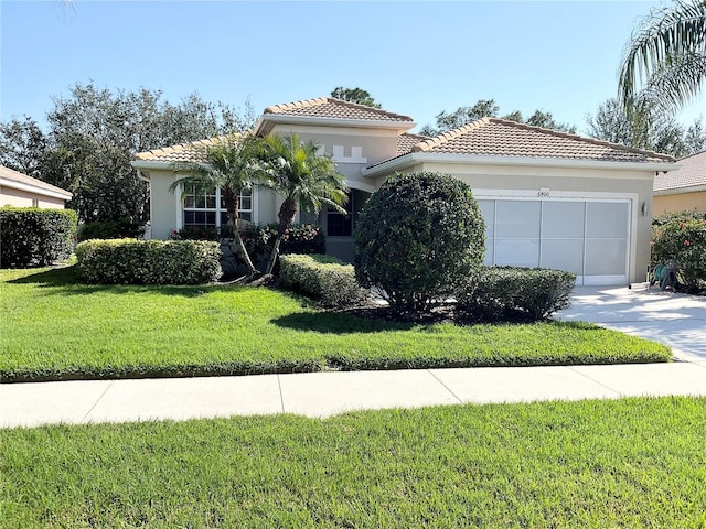 mediterranean / spanish-style house with a garage and a front lawn