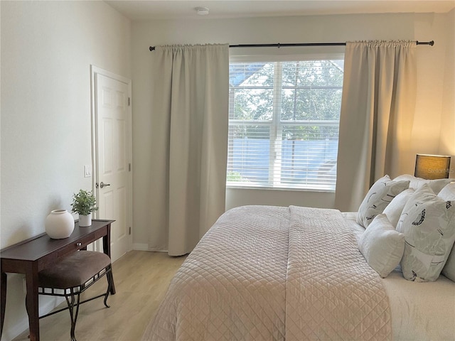 bedroom featuring multiple windows and light wood-type flooring