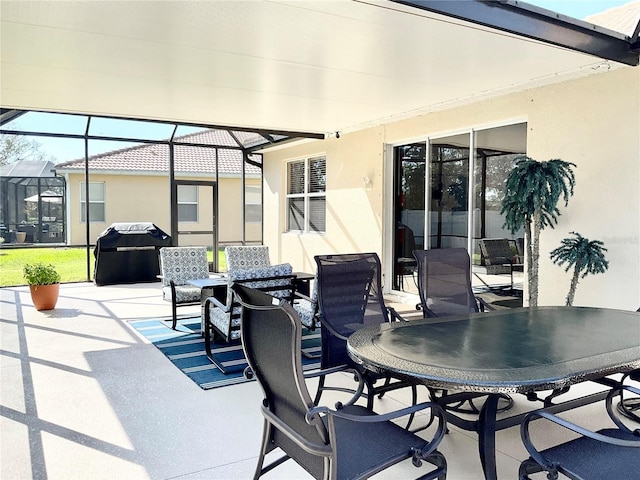 view of patio with area for grilling and a lanai