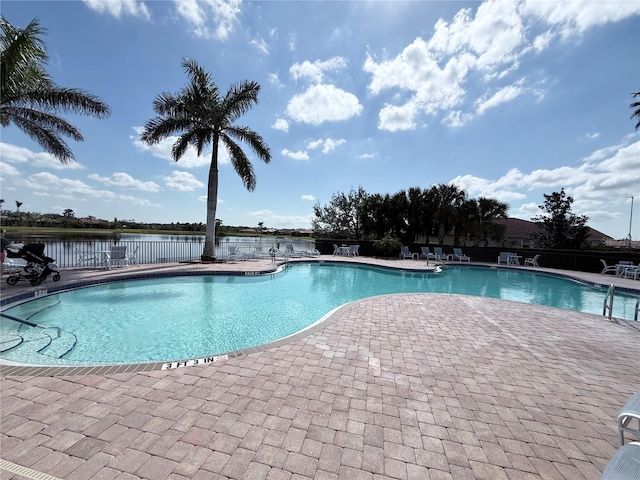 view of swimming pool with a patio and a water view