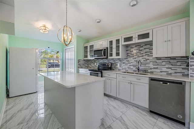 kitchen featuring appliances with stainless steel finishes, a center island, sink, and white cabinets