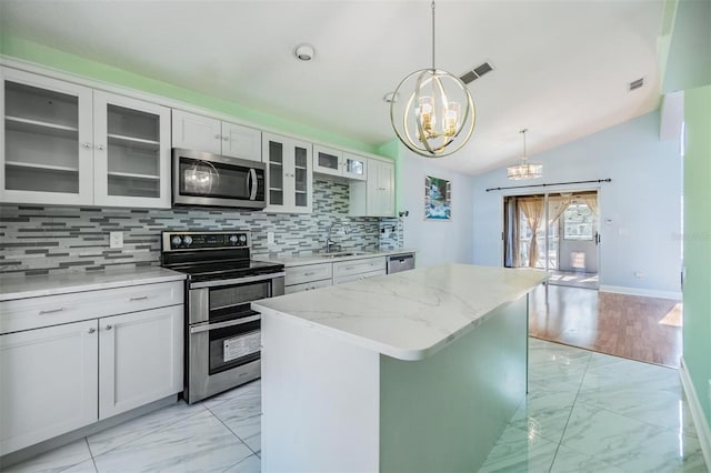 kitchen featuring sink, an inviting chandelier, stainless steel appliances, white cabinets, and a kitchen island