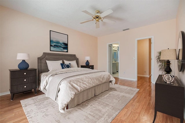 bedroom with ensuite bath, light hardwood / wood-style flooring, and ceiling fan