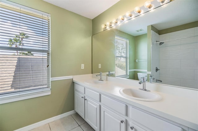 bathroom with vanity, toilet, tile patterned flooring, and a tile shower