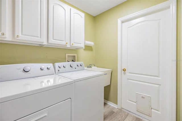 washroom with cabinets, separate washer and dryer, and light wood-type flooring