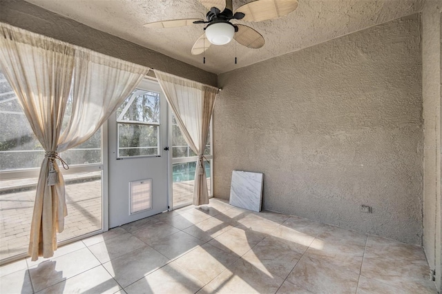 unfurnished room with ceiling fan and light tile patterned floors