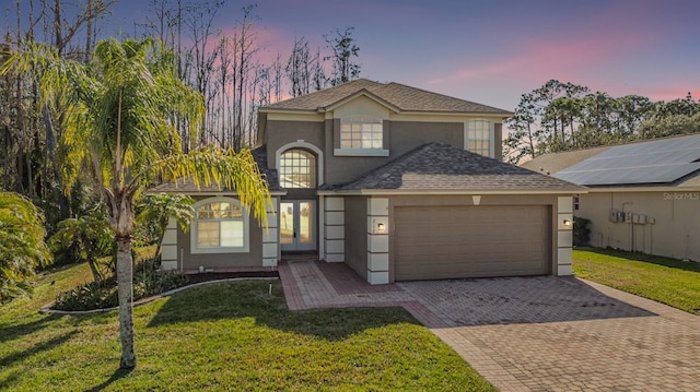 view of front of house featuring a garage and a yard