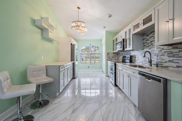 212 Arbor Woods Cir, Oldsmar, FL 34677 - kitchen featuring a notable chandelier, a sink, stainless steel appliances, decorative backsplash, and marble finish floor