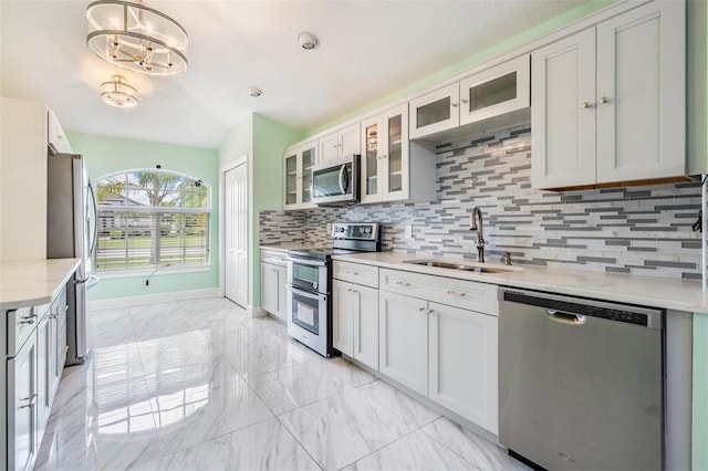 212 Arbor Woods Cir, Oldsmar, FL 34677 - kitchen with glass insert cabinets, appliances with stainless steel finishes, marble finish floor, a sink, and decorative backsplash
