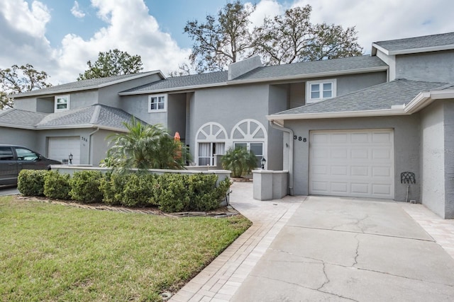 view of property featuring a garage and a front yard