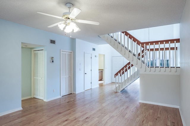 unfurnished living room featuring a textured ceiling, light hardwood / wood-style flooring, and ceiling fan