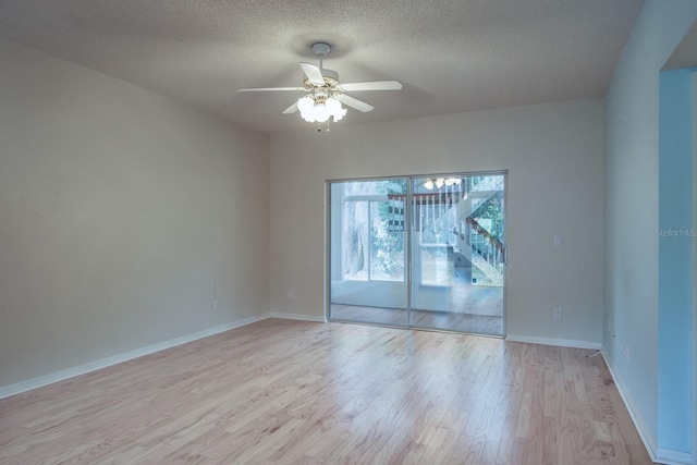 empty room with ceiling fan, a textured ceiling, and light wood-type flooring