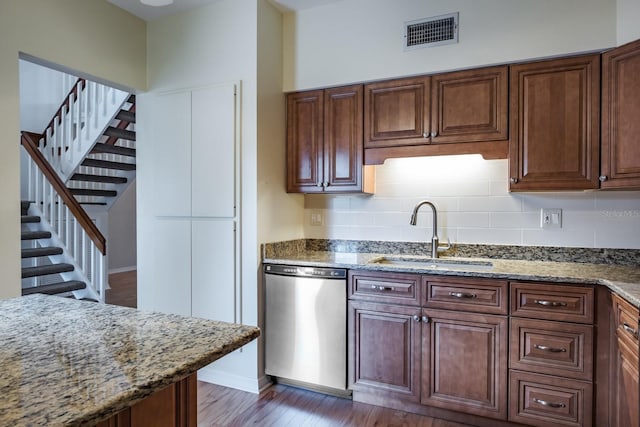 kitchen with dishwasher, sink, backsplash, dark hardwood / wood-style flooring, and light stone counters