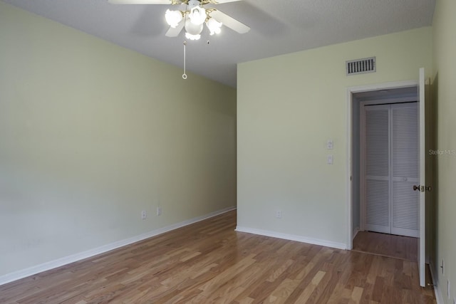 spare room with ceiling fan and light wood-type flooring