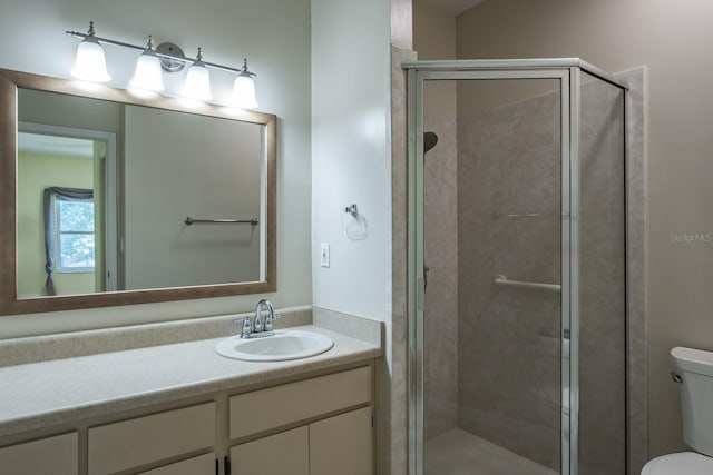 bathroom with vanity, a shower with shower door, and toilet