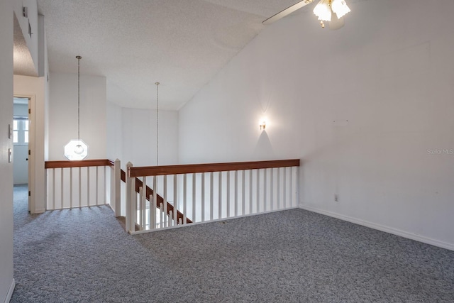 hall with vaulted ceiling, a textured ceiling, and carpet flooring