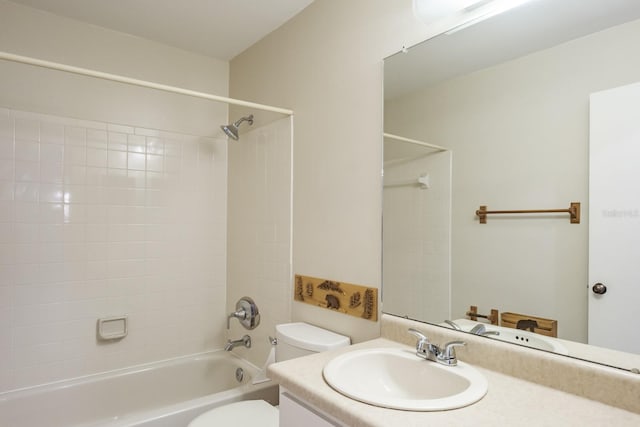 full bathroom with tiled shower / bath, vanity, and toilet