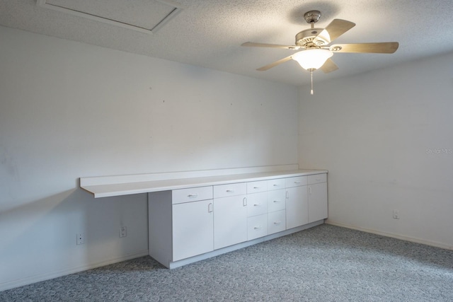 unfurnished room featuring ceiling fan, light colored carpet, and a textured ceiling