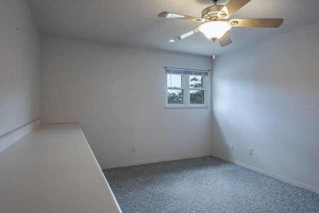 empty room with ceiling fan, carpet flooring, and a textured ceiling