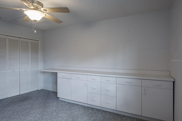 interior space with ceiling fan, a closet, light carpet, and a textured ceiling