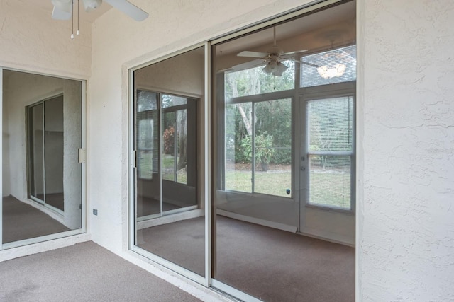 exterior space featuring ceiling fan and carpet floors