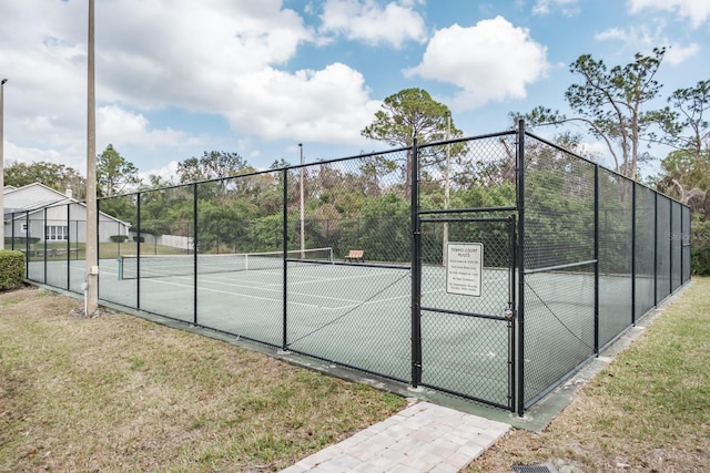 view of tennis court with a yard