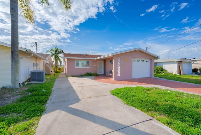 single story home featuring cooling unit and a garage