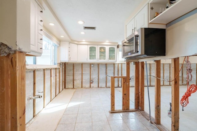 5033 Blue Heron Dr, New Port Richey, FL 34652 - kitchen featuring white cabinets and light tile patterned flooring