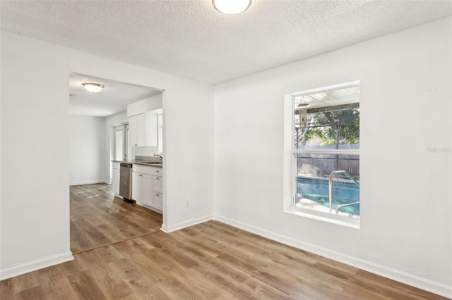 spare room with sink, hardwood / wood-style floors, and a textured ceiling