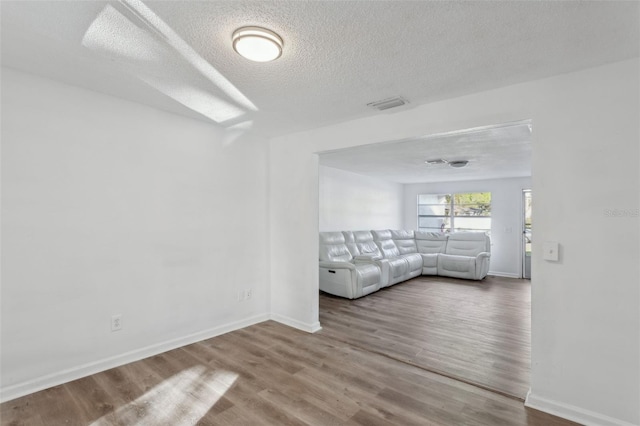 unfurnished living room featuring hardwood / wood-style floors and a textured ceiling