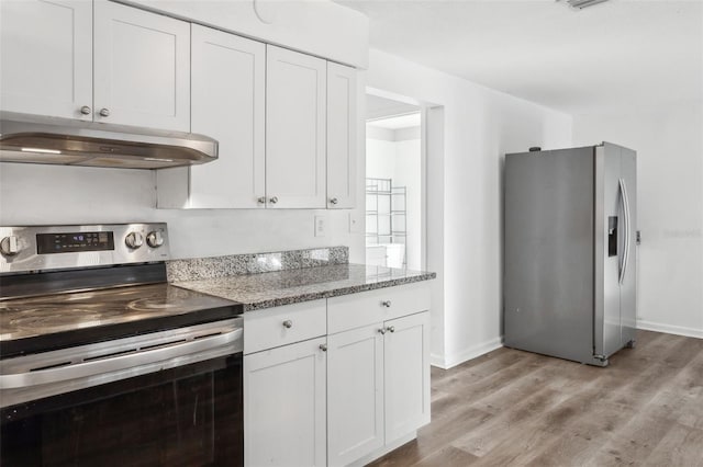 kitchen featuring dark stone countertops, light hardwood / wood-style floors, white cabinets, and appliances with stainless steel finishes