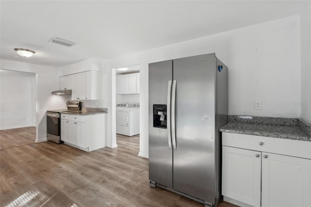 kitchen featuring light stone countertops, appliances with stainless steel finishes, white cabinets, and washer and clothes dryer