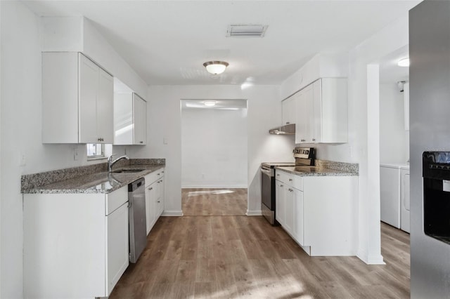 kitchen with sink, washing machine and dryer, white cabinets, and appliances with stainless steel finishes