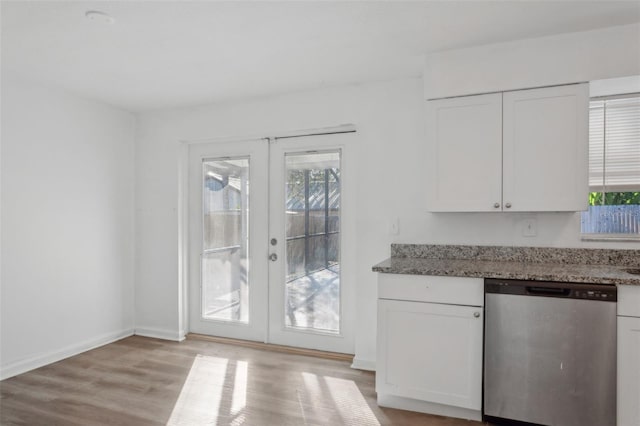 kitchen with light hardwood / wood-style flooring, dishwasher, white cabinetry, dark stone countertops, and french doors