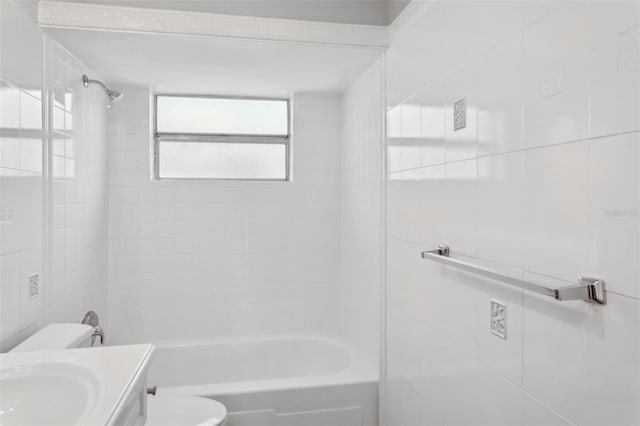 full bathroom with vanity, tiled shower / bath combo, tile walls, and toilet