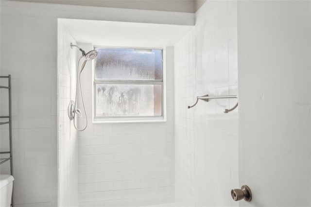 bathroom with toilet and a tile shower