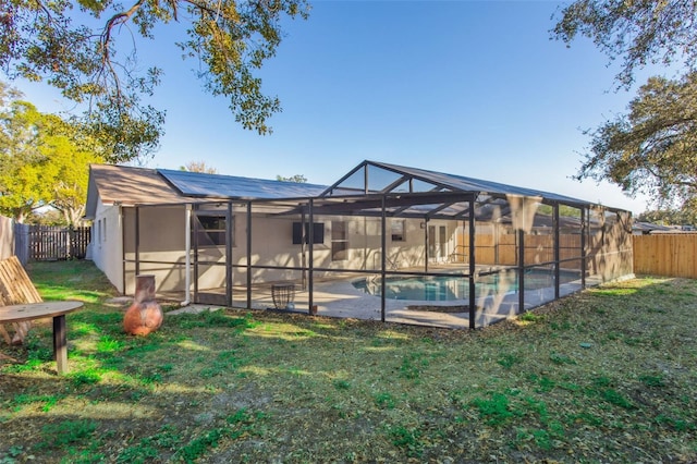 exterior space featuring a fenced in pool, a lanai, a yard, and solar panels