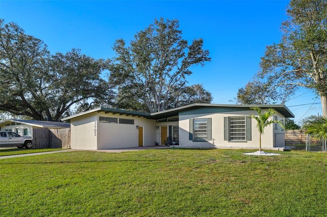 ranch-style house featuring a garage and a front lawn