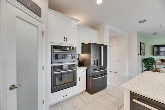 kitchen with visible vents, white cabinets, fridge with ice dispenser, dishwasher, and multiple ovens