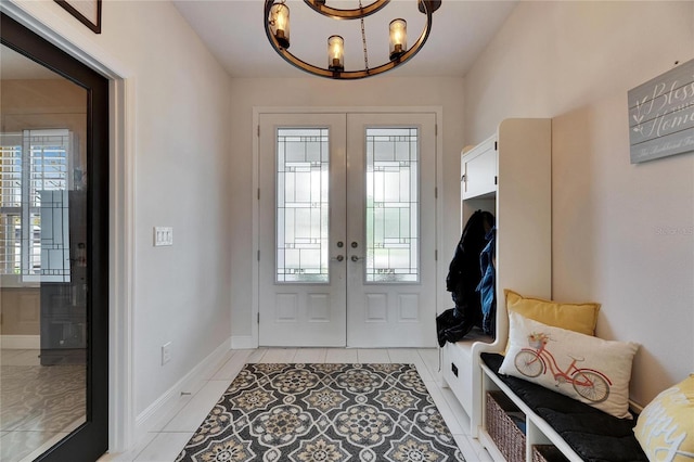 mudroom featuring a chandelier, french doors, baseboards, and light tile patterned floors